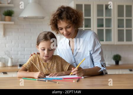 La cura della nonna millenaria aiuta il bambino a disegnare la foto nell'album Foto Stock