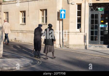 Tre pedoni camminano per le strade della città in una giornata di sole inverno Foto Stock