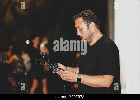 Un fotografo che scatta foto e video di matrimoni, un fotografo che realizza impostazioni per le attrezzature Foto Stock