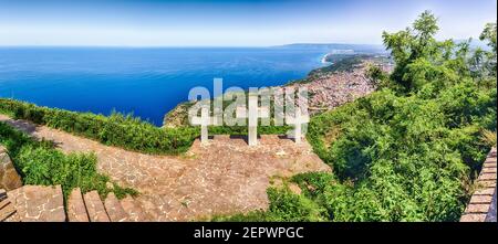 Le tre Iconiche Croci sulla cima del Monte Sant'Elia si affacciano sulla città di Palmi sul Mar Tirreno, in Italia Foto Stock