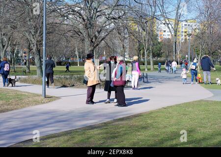Budapest, Ungheria - 28 febbraio 2021: Donne anziane in maschera che parlano in un parco a Budapest Foto Stock