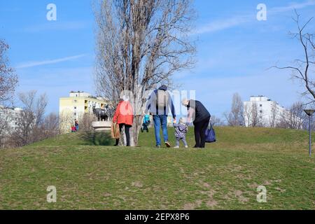 Budapest, Ungheria - 28 febbraio 2021: Nonne in maschere di faccia e papà con bambino che cammina nel parco di Bikas in una giornata di sole inverno Foto Stock
