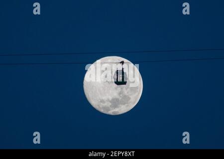 Santiago, Metropolitana, Cile. 28 Feb 2021. La luna piena di febbraio, chiamata Luna di neve, si pone dietro una funivia turistica a Santiago. Credit: Matias Basualdo/ZUMA Wire/Alamy Live News Foto Stock