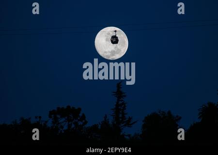 Santiago, Metropolitana, Cile. 28 Feb 2021. La luna piena di febbraio, chiamata Luna di neve, si pone dietro una funivia turistica a Santiago. Credit: Matias Basualdo/ZUMA Wire/Alamy Live News Foto Stock