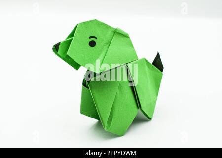 Cane origami verde isolato su sfondo bianco.soddisfacente arte con carta. Foto Stock