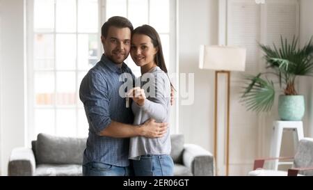 Ritratto di felice millenario uomo e donna che abbracciano a casa Foto Stock
