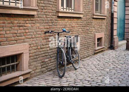 Tipica vecchia strada nella storica Düsseldorf vecchia con un edificio in pietra di mattoni, una vecchia bicicletta e un pavimento in ciottoli. Filtro vintage. Foto Stock