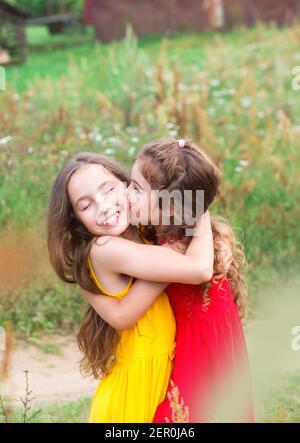 Ritratto di due carissime bambine che abbracciano e ridono sul campo. Felici i bambini all'aperto Foto Stock