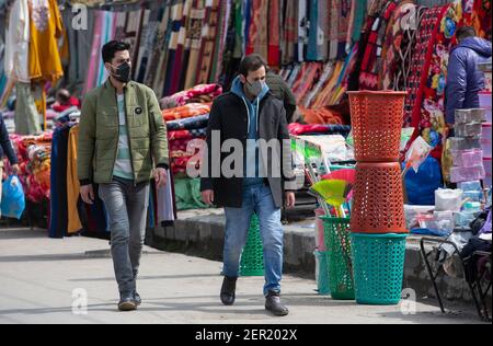 Srinagar, Kashmir controllato dall'India. 28 Feb 2021. Le persone che indossano maschere facciali camminano in un mercato nella città di Srinagar, la capitale estiva del Kashmir controllato dagli Indiani, 28 febbraio 2021. Credit: Javed Dar/Xinhua/Alamy Live News Foto Stock