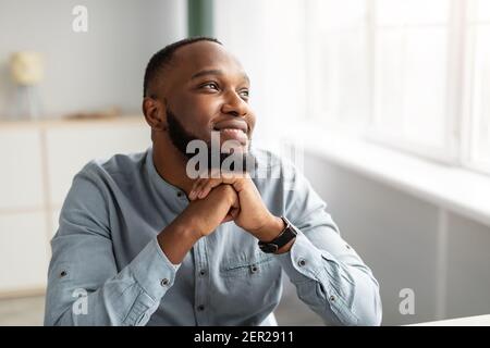 Uomo d'affari nero sognare di successo Carriera seduta in ufficio Foto Stock