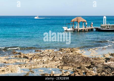 La vista mattutina del molo dei subacquei con un tetto di paglia su una riva dell'isola di Cozumel (Messico). Foto Stock