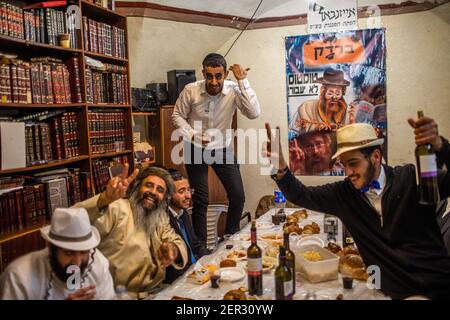 Gerusalemme, Israele. 28 Feb 2021. Uomini ebrei ultra ortodossi prendono parte alle celebrazioni della festa ebraica di Purim nel quartiere Mea She'arim di Gerusalemme. Purim, chiamato anche Festival of Lots, è una festa ebraica simile a carnevale che commemora la salvezza del popolo ebraico da un complotto per massacrare tutti gli ebrei nell'antico impero persiano, come raccontato nel Libro di Esther. Credit: Ilia Yefimovich/dpa/Alamy Live News Foto Stock