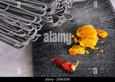 Primo piano di fette di bottarga (uova di pesce essiccate) e peperoncino Foto Stock