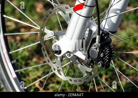 Freno idraulico a disco anteriore su mountain bike con mozzo, pinza e raggi. Foto Stock