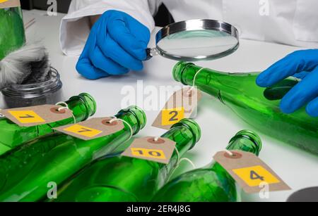 Esperto di polizia diventa campione di sangue dalla bottiglia di vetro in Criminalistic Lab Foto Stock