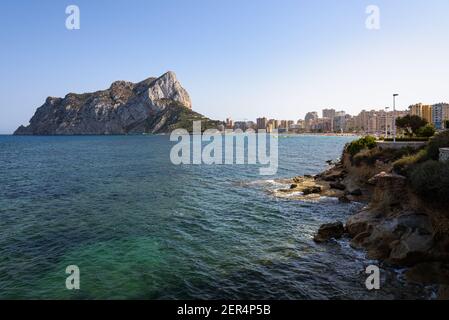 Costa con la spiaggia urbana di Calpe e la falesia sullo sfondo, Alicante, Spagna Foto Stock