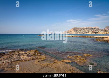 Mare della costa di Calpe con una spiaggia rocciosa urbana, Alicante, Spagna Foto Stock