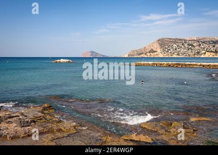 Mare della costa di Calpe con una spiaggia rocciosa urbana, Alicante, Spagna Foto Stock