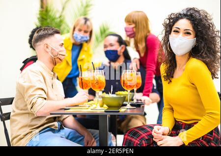 Persone multirazziali che bevono spritz con maschera aperta al cocktail Bar - nuovo concetto di stile di vita normale circa amici felici che hanno divertimento insieme toastin Foto Stock