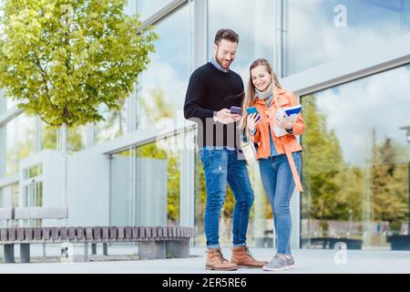 Donna e uomo che studiano insieme nel campus universitario Foto Stock