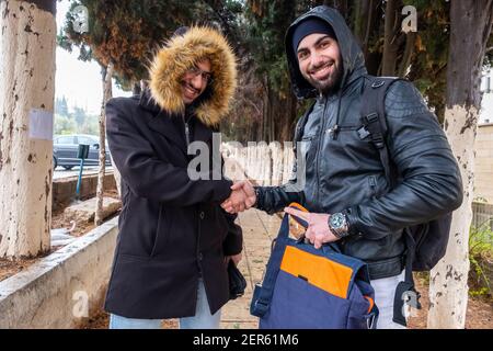 Felici amici musulmani che scuotono le mani all'università Foto Stock