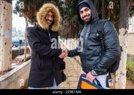 Felici amici musulmani che scuotono le mani all'università Foto Stock