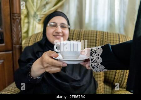 Donna musulmana serviong il suo ospite un po 'di tè Foto Stock