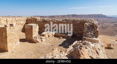 Pareti interne in pietra e colonne dell'antica Makhmal Nabatea Fortezza sul bordo del cratere Maktesh Ramon Israele con il monte Ardon e un pazzo Foto Stock