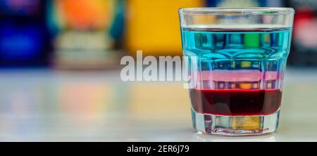 Una bevanda colorata a strati sparata su un bar preparato da barman, tempo di festa Foto Stock