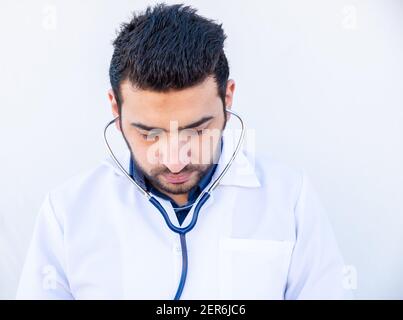 Ragazzo arabo che usa stetoscopio per ascoltare la frequenza cardiaca della gente Foto Stock