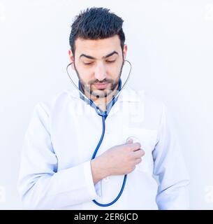 Ragazzo arabo che usa stetoscopio per ascoltare la frequenza cardiaca della gente Foto Stock