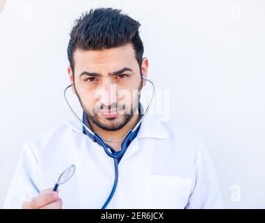Ragazzo arabo che usa stetoscopio per ascoltare la frequenza cardiaca della gente Foto Stock