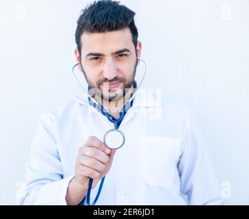Ragazzo arabo che usa stetoscopio per ascoltare la frequenza cardiaca della gente Foto Stock