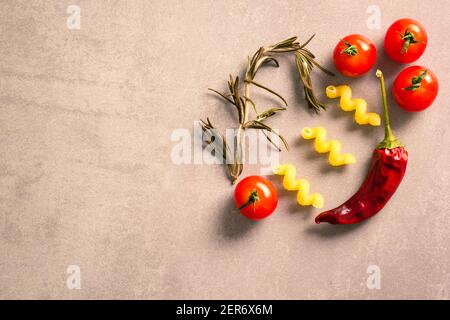 Pomodori maturi, rosmarino, pasta di cavatappi e un peperoncino rosso essiccato disposto su un piano Foto Stock