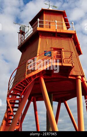 Il gregge dipinto di rosso brillante Groyne Lighhouse si trova nella foce del fiume Tyne a Littlehaven, South Shields in Tyne e indossare. Foto Stock