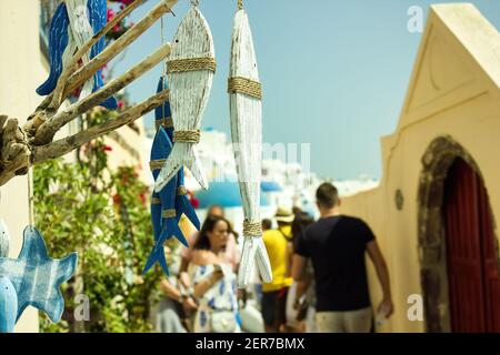 Santorini, Grecia - 11 settembre 2017: Oggetto di pesce in legno appeso per scopi decorativi che si abbina con i colori dell'architettura della famosa grea Foto Stock