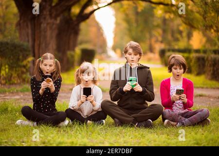 Gruppo di bambini che guardano insieme film cartoni animati su tablet digitale. Bambini che giocano insieme con il telefono Foto Stock