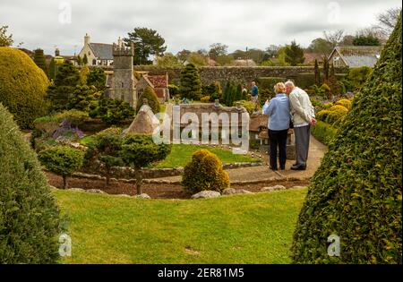 Isle of Wight, Regno Unito 04-25-2010 coppie caucasiche anziane visitano il famoso villaggio modello Godshill. Questa città in miniatura ha modelli in scala di storia Foto Stock