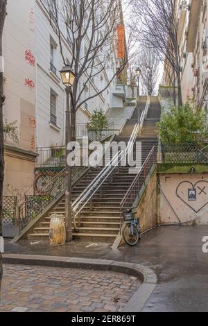 Parigi, Francia - 02 26 2021: Quartiere di Montmartre. Scala in pietra con lanterne illuminate Foto Stock