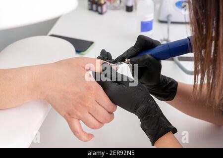 Un tecnico professionale levigatrice, smalto per unghie, professionale cura mani unghie Foto Stock