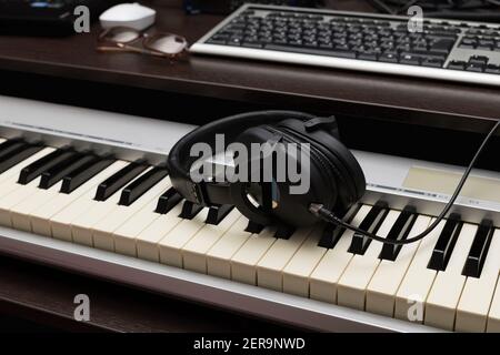 Una pausa durante il lavoro di compositore. Cuffie sul sintetizzatore Foto Stock