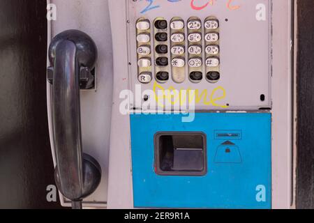 vecchio telefono pubblico con tastiera rotta. Foto Stock