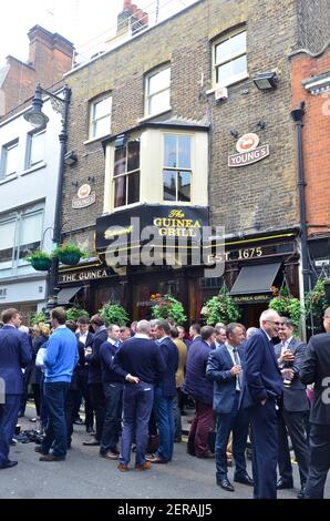 Persone che bevono fuori dal pub Guinea a Mayfair, Londra Foto Stock