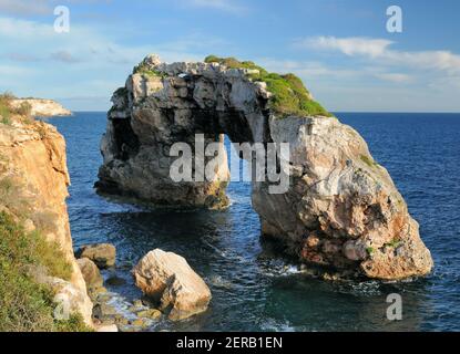 Famoso arco di roccia es Pontas presso la Costa rocciosa di Il Mar Mediterraneo a Santanyi sulle Isole Baleari Mallorca ON Un giorno invernale soleggiato con un azzurro chiaro Foto Stock