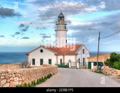 Faro con tetto rosso edificio di Punta De Capdepera di fronte Del mare vicino Cala Rajada sull'isola Baleari Mallorca In UN giorno invernale soleggiato con alcuni Foto Stock