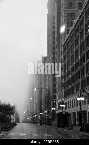 vuota strada della città con edifici alti in una mattinata foggosa Foto Stock