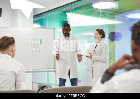 Ritratto dell'uomo afroamericano che parla con il pubblico mentre dà la presentazione durante il seminario medico in università, spazio di copia Foto Stock