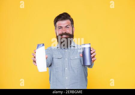 Essenziale per una buona igiene. Bottigliette per gel e shampoo hippster. Uomo con bearded con prodotti di igiene. Cosmetici e articoli da toeletta. Abitudini di igiene personale. Igiene e salute. Foto Stock