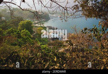 Vista aerea sulla costa del villaggio locale lungo il lago Atitlan attraverso gli alberi, San Juan la Laguna, Guatemala Foto Stock