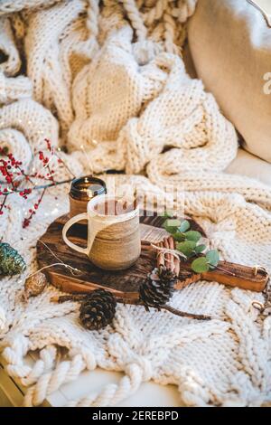 Tradizionale salep di bevande calde turche durante l'inverno. Tazza di dolce salep caldo bevanda con cannella macinata su vassoio sopra coperta a maglia nel letto. Mare turco Foto Stock